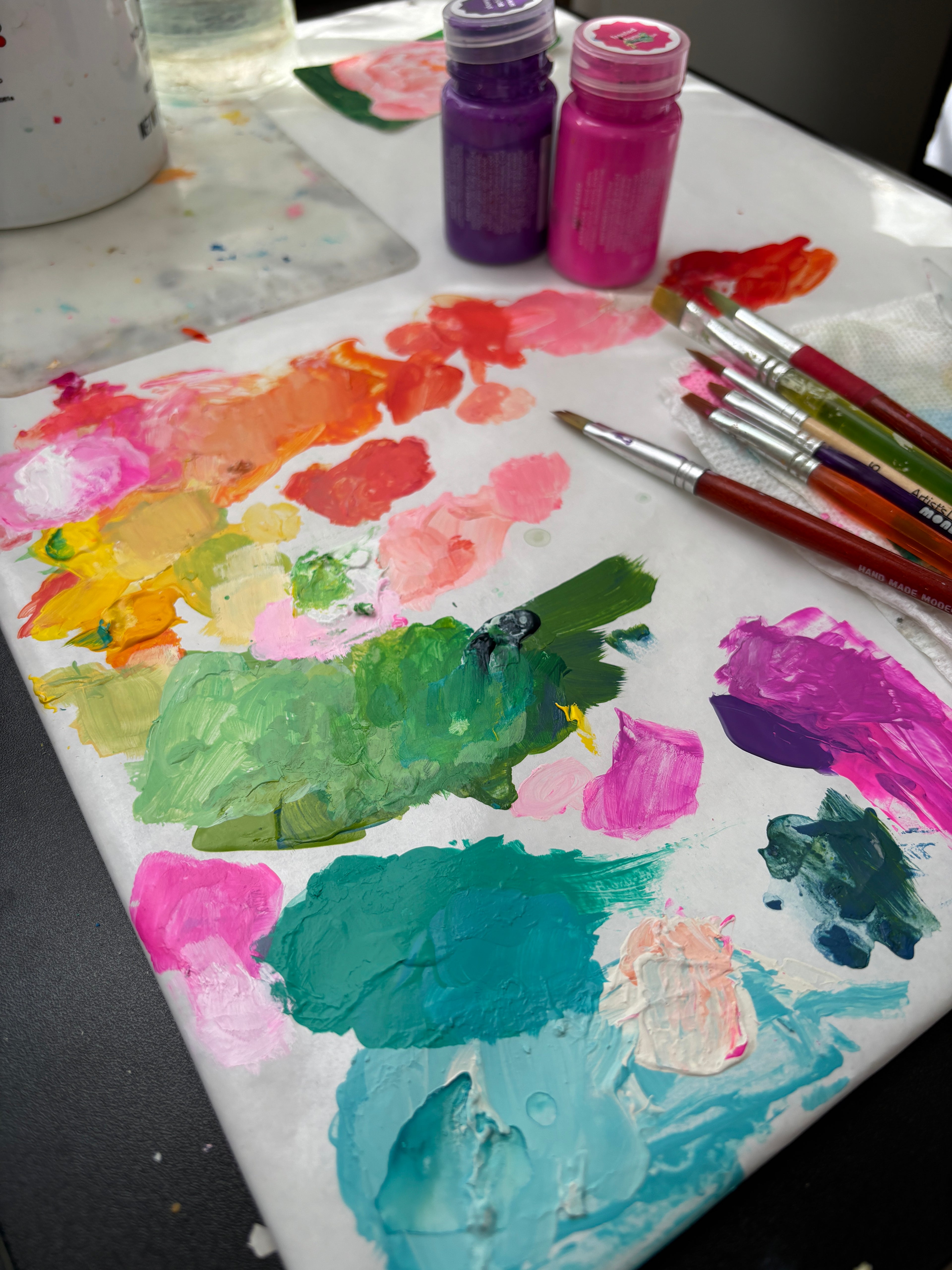 Paint palette covered in vibrant mixes of colors